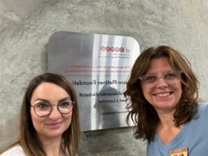 Standford_uczestniczki wyjazdu przy ścianie zewnętrznej budynku z tabliczką uczelni